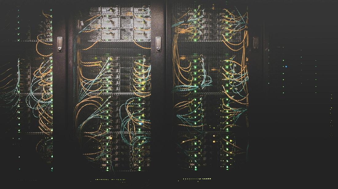 Data-centre server racks glowing with network cabling
