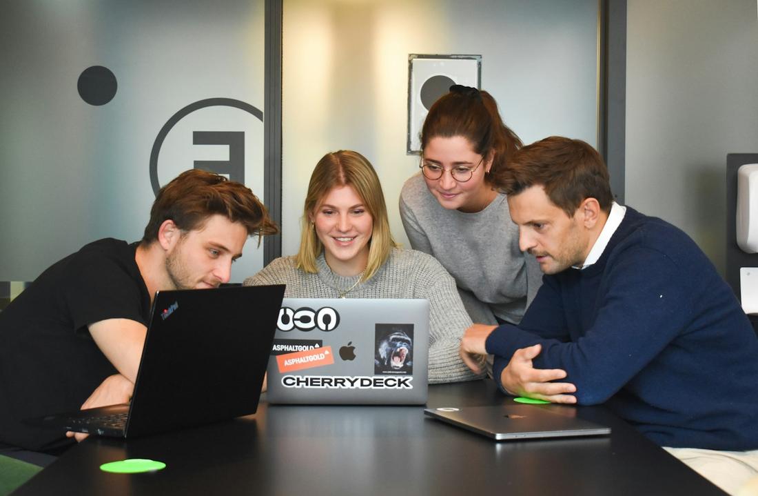 A small team collaborating around laptops